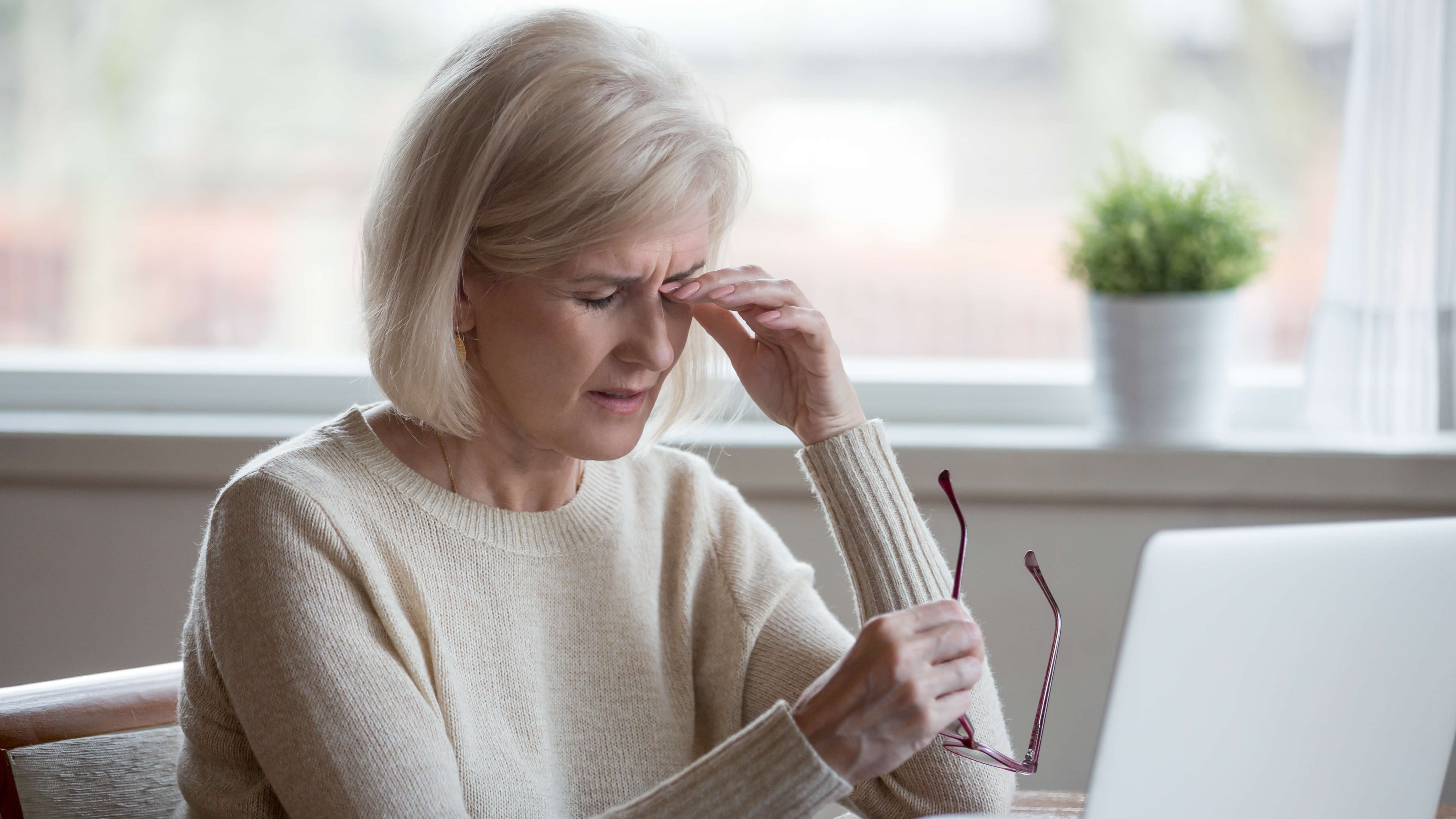 woman closing her eyes in pain